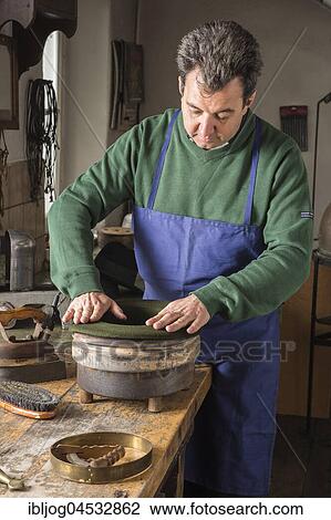Stock Image - Hatter pushing dry wool felt hat into edge mold, hatmaker workshop, Bad Aussee, Styria, Austria, Europe. Fotosearch
