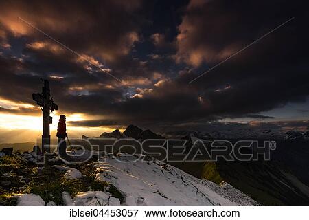 Hiker next to cross on Zafernhorn summit at sunrise with dark clouds, stormy atmosphere, Allgäu Alps, Damüls, Bregenz Forest, Vorarlberg, Austria, Europe View Large Photo Image Stock Photo - Hiker next to cross on Zafernhorn summit at sunrise with dark clouds, stormy atmosphere, Allgäu Alps, Damüls, Bregenz Forest, Vorarlberg, Austria, Europe. Fotosearch