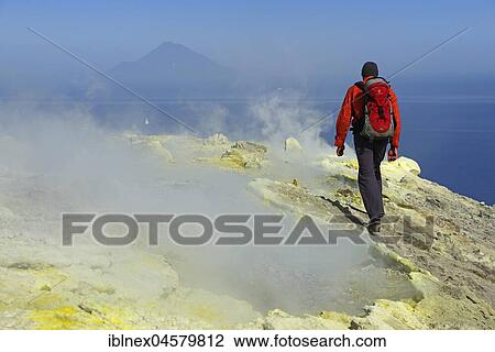 Stock Image - Hiker on the Gran Cratere walks through sulphur fumaroles, Vulcano Island, Liparic Islands, Italy, Europe. Fotosearch