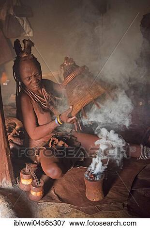 Stock Photo - Himba woman, disinfecting clothes, Kaokoveld, Namibia, Africa. Fotosearch