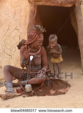Stock Photo - Himba woman with child in front of the mud hut, Kaokoveld, Namibia, Africa. Fotosearch