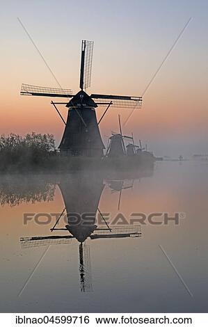 Historical windmills in the early mist, UNESCO World Heritage Site, Kinderdijk, province of South Holland, Netherlands View Large Photo Image Stock Photograph - Historical windmills in the early mist, UNESCO World Heritage Site, Kinderdijk, province of South Holland, Netherlands. Fotosearch