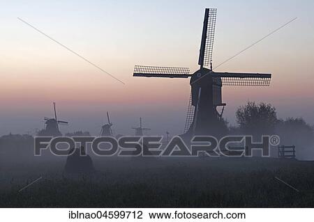 Historical windmills in the early morning fog at dawn, UNESCO World Heritage Site, Kinderdijk, province of South Holland, Netherlands View Large Photo Image Stock Image - Historical windmills in the early morning fog at dawn, UNESCO World Heritage Site, Kinderdijk, province of South Holland, Netherlands. Fotosearch