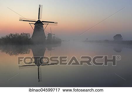 Historical windmills in the early morning fog at dawn, UNESCO World Heritage Site, Kinderdijk, province of South Holland, Netherlands View Large Photo Image Stock Photo - Historical windmills in the early morning fog at dawn, UNESCO World Heritage Site, Kinderdijk, province of South Holland, Netherlands. Fotosearch
