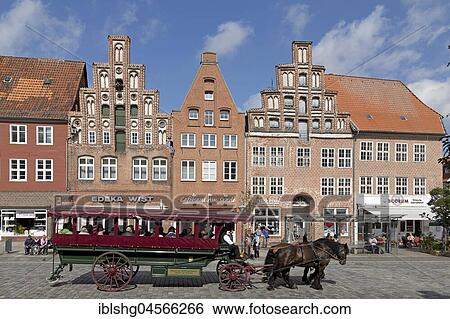 Stock Photograph - Horse-drawn carriage in front of brick houses, Am Sande, Lüneburg, Lower Saxony, Germany, Europe. Fotosearch