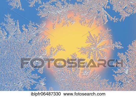 Stock Image - Ice flowers on glass pane in candlelight. Fotosearch
