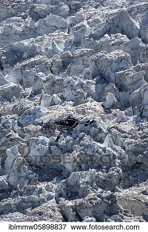 Stock Photo - Injured person on rope, helicopter flying over glacier, Glacier de Bossons, alpine rescue, mountain rescue, Chamonix, Haute-Savoie, France, Europe. Fotosearch