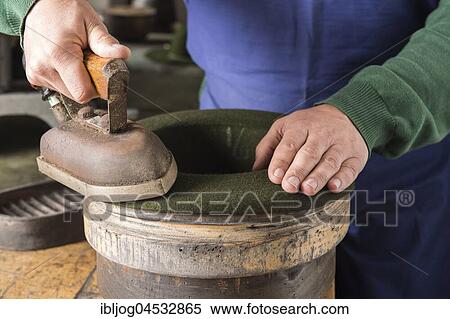 Stock Photography - Ironing a dry wool felt hat over edge mold, hatmaker workshop, Bad Aussee, Styria, Austria, Europe. Fotosearch