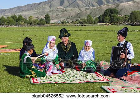 Kazakh family in traditional clothes listening to the music of an accordion player, Sati village, Tien Shan Mountains, Kazakhstan, Asia View Large Photo Image Stock Image - Kazakh family in traditional clothes listening to the music of an accordion player, Sati village, Tien Shan Mountains, Kazakhstan, Asia. Fotosearch