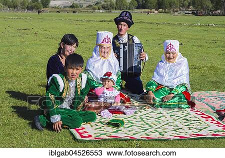 Kazakh family in traditional clothes listening to the music of an accordion player, Sati village, Tien Shan Mountains, Kazakhstan, Asia View Large Photo Image Stock Image - Kazakh family in traditional clothes listening to the music of an accordion player, Sati village, Tien Shan Mountains, Kazakhstan, Asia. Fotosearch