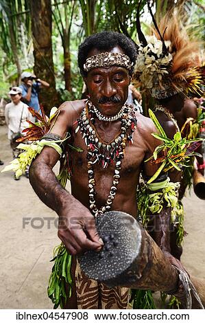 Korafe-Mann tunes his drum with tree resin, McLaren-Harbour, Tufi, Papua New Guinea, Oceania View Large Photo Image Stock Photo - Korafe-Mann tunes his drum with tree resin, McLaren-Harbour, Tufi, Papua New Guinea, Oceania. Fotosearch