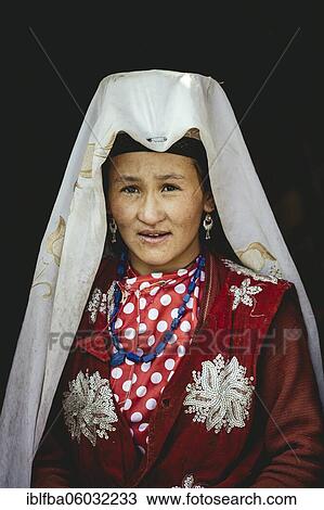 Stock Image - Kyrgyz nomad with traditional traditional traditional traditional traditional traditional traditional traditional traditional traditional costume, white headgear and jewellery at the entrance of a yurt, Bozai Gumbaz, Saradh-e-Broghil, Afghanistan, Asia. Fotosearch
