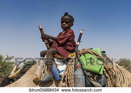 Little boy on a camel with a caravan of Peul nomads with their animals in the Sahel of Niger View Large Photo Image Picture - Little boy on a camel with a caravan of Peul nomads with their animals in the Sahel of Niger. Fotosearch