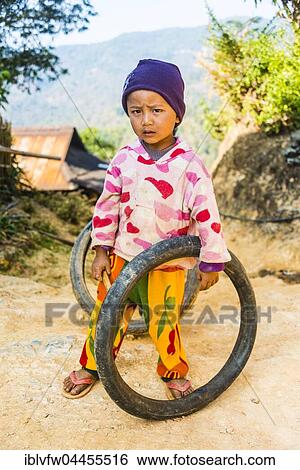 Stock Photograph - Little boy with tires as toys, Palaung hilltribe, Palaung Village in Kyaukme, Shan State, Myanmar, Asia. Fotosearch