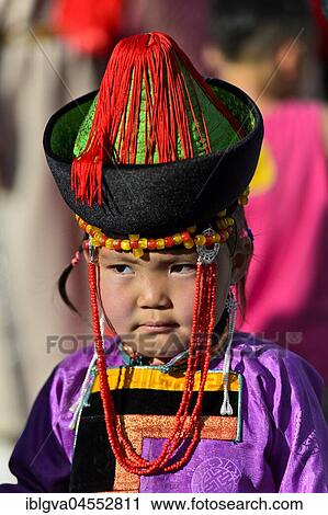 Stock Image - Little girl in traditional Deel clothes and hat with cone-shaped lace, festival of Mongolian National Festival, Ulanbator, Mongolia, Asia. Fotosearch