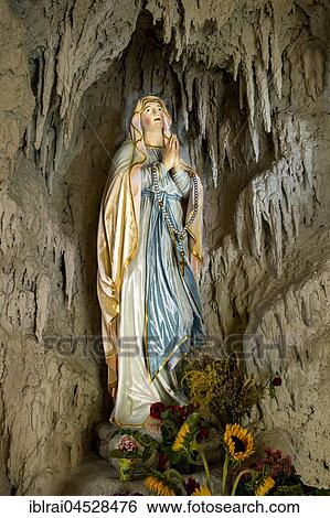 Lourdes grotto with a statue of the Virgin Mary, reconstruction of the grotto of Massabielle near Lourdes, parish church of St. John Baptist, Pfaffenhofen, Oberbayern, Bavaria, Germany, Europe View Large Photo Image Stock Photograph - Lourdes grotto with a statue of the Virgin Mary, reconstruction of the grotto of Massabielle near Lourdes, parish church of St. John Baptist, Pfaffenhofen, Oberbayern, Bavaria, Germany, Europe. Fotosearch