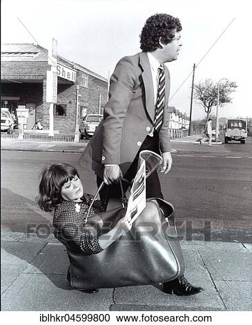Stock Image - Man carries woman in bag, England, Great Britain. Fotosearch