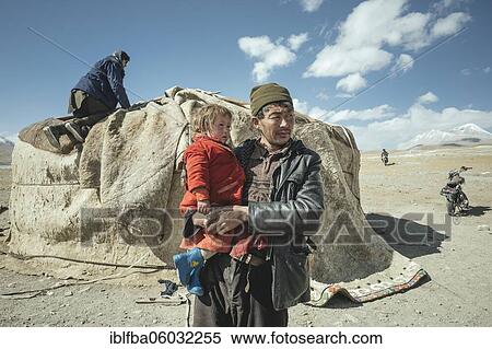 Man carrying child in his arms, nomadic Kyrgyz, behind him traditional yurt, which is being dismantled, Bozai Gumbaz plateau, Wakhan corridor, Badakhshan, Afghanistan, Asia View Large Photo Image Stock Photography - Man carrying child in his arms, nomadic Kyrgyz, behind him traditional yurt, which is being dismantled, Bozai Gumbaz plateau, Wakhan corridor, Badakhshan, Afghanistan, Asia. Fotosearch