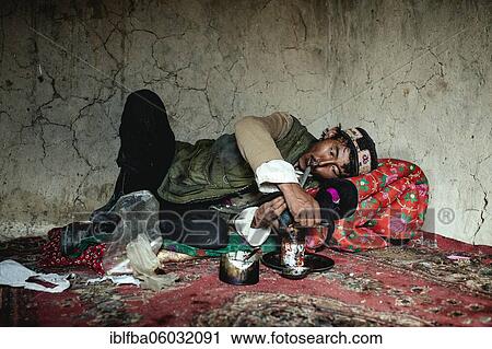 Man lying on a carpet, pulling an opium pipe, Bozai Gumbaz, Wakhan Corridor, Badakhshan, Afghanistan, Asia View Large Photo Image Stock Image - Man lying on a carpet, pulling an opium pipe, Bozai Gumbaz, Wakhan Corridor, Badakhshan, Afghanistan, Asia. Fotosearch
