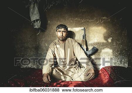 Man sitting on a mattress on the floor in a house, behind him an AK-47, police officer, Saradh-e-Broghil, Wakhan corridor, Afghanistan, Asia View Large Photo Image Stock Photo - Man sitting on a mattress on the floor in a house, behind him an AK-47, police officer, Saradh-e-Broghil, Wakhan corridor, Afghanistan, Asia. Fotosearch