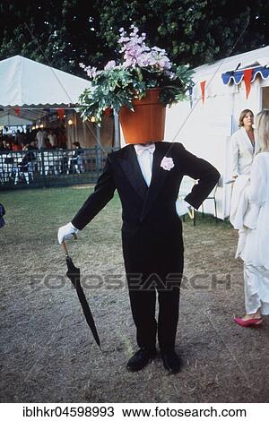 Stock Image - Man with flowerpot on his head, England, Great Britain. Fotosearch