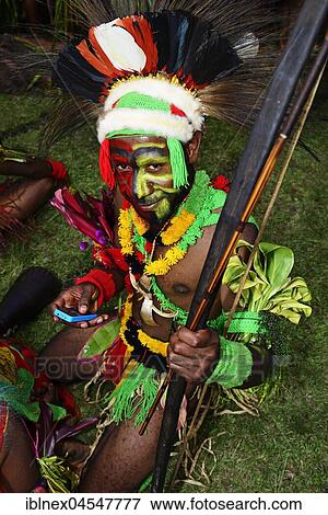 Mehi warrior typing into his smartphone, the highland tribes presenting themselves at the annual Sing Sing of Goroka, Papua New Guinea, Oceania View Large Photo Image Stock Photo - Mehi warrior typing into his smartphone, the highland tribes presenting themselves at the annual Sing Sing of Goroka, Papua New Guinea, Oceania. Fotosearch