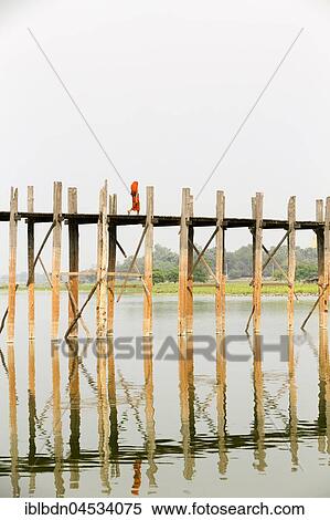 Stock Photography - Monk crossing U Bein bridge, Taungthaman Lake, Mandalay region, Myanmar, Asia. Fotosearch