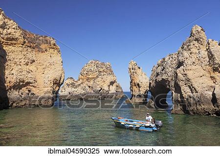Motorboat in front of rugged cliffs, bizarre rock formation, Ponta da Piedade, near Lagos, Algarve, Portugal, Europe View Large Photo Image Stock Photography - Motorboat in front of rugged cliffs, bizarre rock formation, Ponta da Piedade, near Lagos, Algarve, Portugal, Europe. Fotosearch