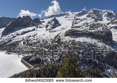 Stock Image - Mountain range Marmolada, highest massif of the Dolomites, on the right Summit Punta Penia, below Reservoir at Passo Fedaia, Canazei, Trentino-Alto Adige, Dolomites, Italy, Europe. Fotosearch