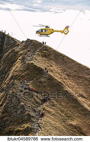 Stock Photograph - Mountain rescue by helicopter on the Fellhorn ridge, Kleinwalsertal, Riezlern, Vorarlberg, Austria, Europe. Fotosearch