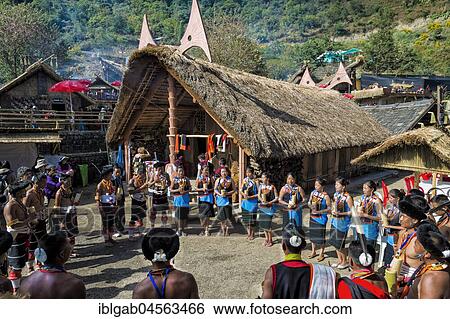 Stock Photograph - Naga tribes people in front of a traditional house, Kisima Nagaland Hornbill festival, Kohima, Nagaland, India, Asia. Fotosearch