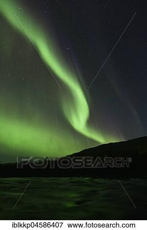 Stock Photo - Northern lights over the river Aisko in Abisko National Park, Sweden, Europe. Fotosearch