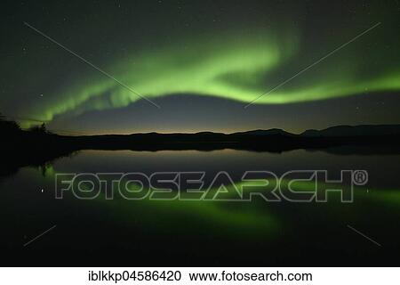 Stock Image - Northern lights reflected in a lake in the Abisko National Park, Sweden, Europe. Fotosearch