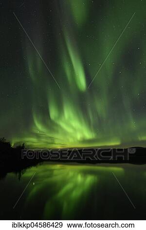Stock Photo - Northern lights reflected in a lake in the Abisko National Park, Sweden, Europe. Fotosearch
