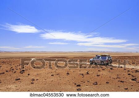Off-road vehicle drives through desert landscape north of the Hoanib River, Damaraland, Kunene region, Namibia, Africa View Large Photo Image Stock Image - Off-road vehicle drives through desert landscape north of the Hoanib River, Damaraland, Kunene region, Namibia, Africa. Fotosearch