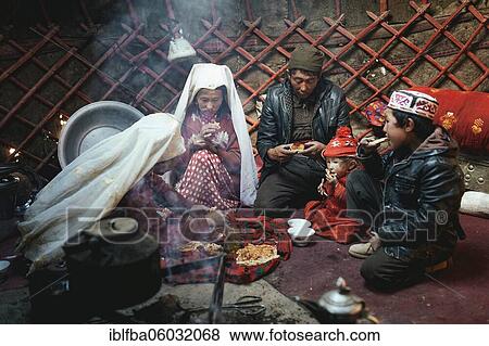 Stock Photo - One man, two woman, two children at mealtime, nomadic Kyrgyz, yurt, Bozai Gumbaz, Wakhan Corridor, Badakhshan, Afghanistan, Asia. Fotosearch
