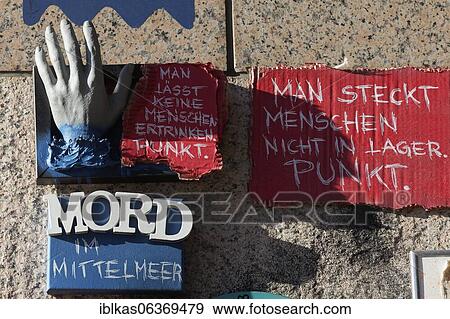 Stock Photo - Outstretched hand and writing Murder in the Mediterranean Sea, Sea rescue of refugees, 3D art object on a wall, Open Air Gallery Flingern, Düsseldorf, North Rhine-Westphalia, Germany, Europe. Fotosearch