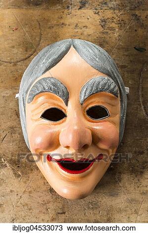 Stock Image - Painted wooden mask on a workbench, wooden mask carver, Bad Aussee, Styria, Austria, Europe. Fotosearch