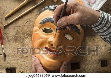 Stock Photo - Painting the face of a wooden mask with a paintbrush, on a workbench, wooden mask carver, Bad Aussee, Styria, Austria, Europe. Fotosearch