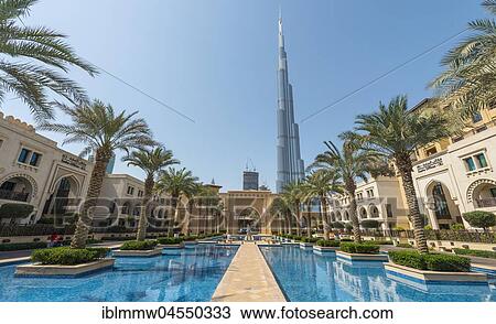 Stock Image - Palace city hotel, palm trees and fountains, at back Burj Khalifa, Dubai, Emirate Dubai, United Arab Emirates, Asia. Fotosearch