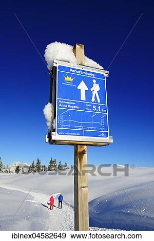 Stock Photo - Panorama trail signpost, hiker in the snow on a premium winter hiking trail, Hemmersuppenalm, Reit im Winkl, Chiemgau, Upper Bavaria, Bavaria, Germany, Europe. Fotosearch
