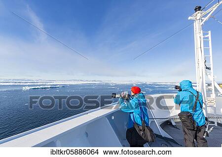 Picture - Passengers on deck of a cruise ship, icebergs, sea, east coast Greenland, Denmark, Europe. Fotosearch