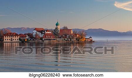 Peninsula with the parish church of St. George in front of the Alps in the evening sun, moated castle on Lake Constance, Swabia, Bavaria, Germany, Europe View Large Photo Image Stock Image - Peninsula with the parish church of St. George in front of the Alps in the evening sun, moated castle on Lake Constance, Swabia, Bavaria, Germany, Europe. Fotosearch