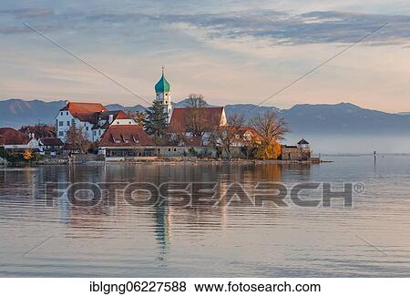 Peninsula with the parish church of St. George in front of the Alps in the evening sun, moated castle on Lake Constance, Swabia, Bavaria, Germany, Europe View Large Photo Image Stock Photo - Peninsula with the parish church of St. George in front of the Alps in the evening sun, moated castle on Lake Constance, Swabia, Bavaria, Germany, Europe. Fotosearch