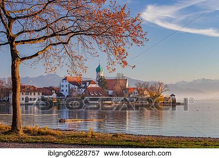 Peninsula with the parish church of St. George in front of the Alps in the evening sun, moated castle on Lake Constance, Swabia, Bavaria, Germany, Europe View Large Photo Image Stock Photo - Peninsula with the parish church of St. George in front of the Alps in the evening sun, moated castle on Lake Constance, Swabia, Bavaria, Germany, Europe. Fotosearch