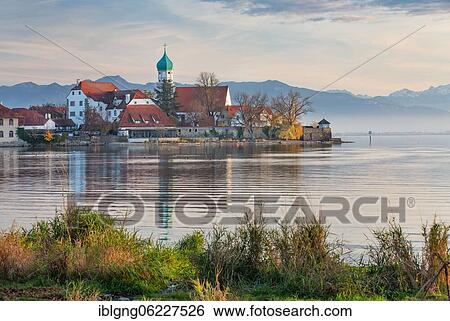 Peninsula with the parish church of St. George in front of the Alps in the evening sun, moated castle on Lake Constance, Swabia, Bavaria, Germany, Europe View Large Photo Image Stock Photograph - Peninsula with the parish church of St. George in front of the Alps in the evening sun, moated castle on Lake Constance, Swabia, Bavaria, Germany, Europe. Fotosearch