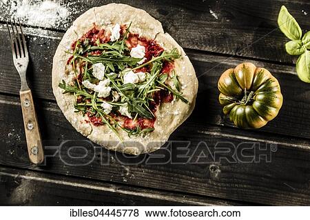 Stock Photo - Pizza on dark wooden table, tomato, basil, fork, South Tyrol, Italy, Europe. Fotosearch