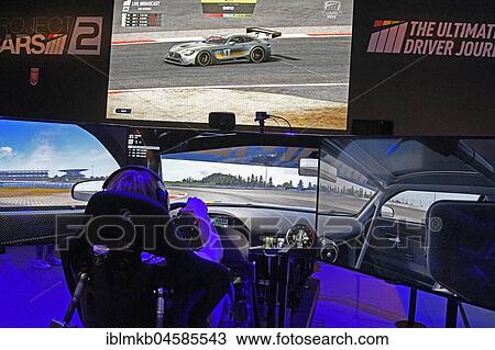 Stock Image - Player sits in a car racing simulation at Gamescom 2017, Europe's largest trade fair for video and computer games from August 22-26, 2017 in Cologne, North Rhine-Westphalia, Germany, Europe. Fotosearch