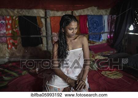 Stock Image - Poppy, prostitute in Banishanta village, sitting on her bed in her hut, Banishanta, Mongla, Sundarbans, Bangladesh, Asia. Fotosearch
