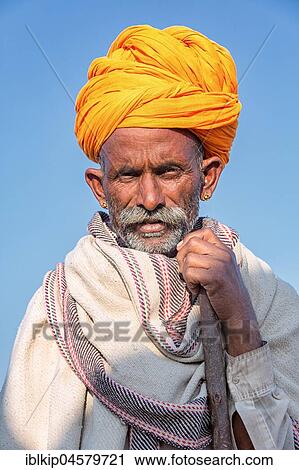 Stock Image - Portrait of a senior Rajasthani and with a yellow turban, Pushkar, Rajasthan, India, Asia. Fotosearch